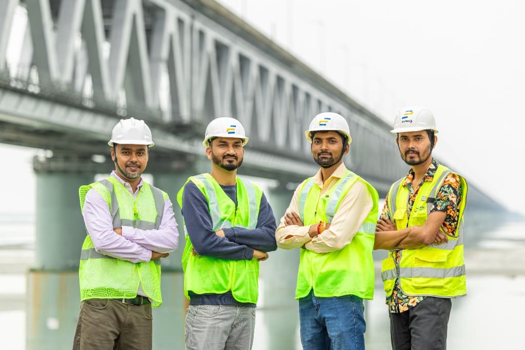 Professional construction and engineering team in front of major bridge infrastructure